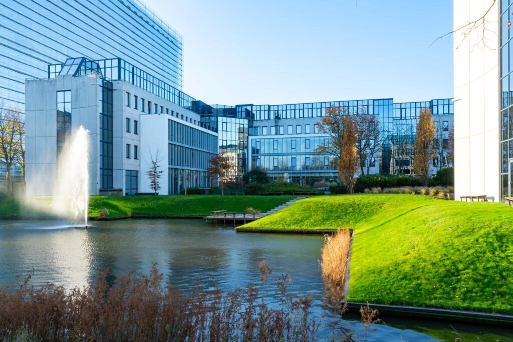 Modern kantoorgebouw aan de De Bruyn Kopsstraat met vijver, fontein en groen aangelegde oever.